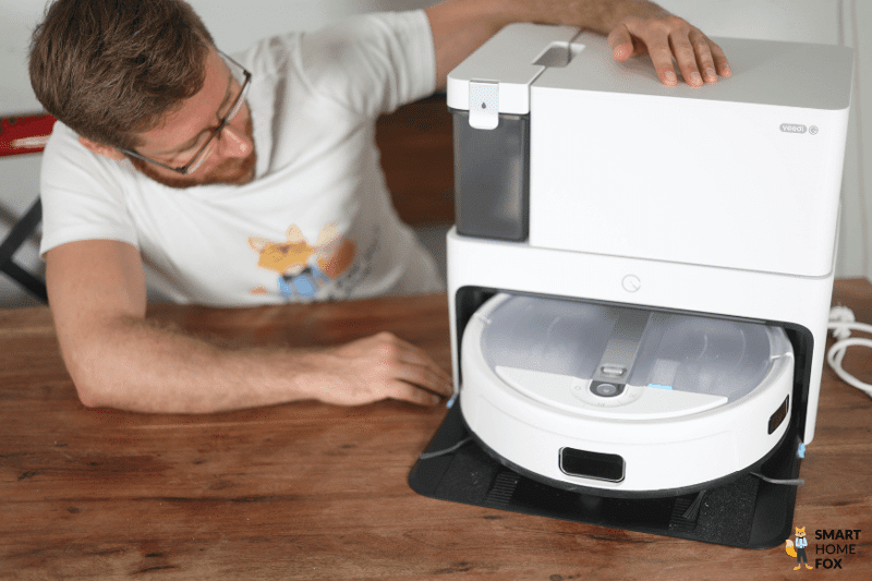 Der Yeedi Cube steht auf dem Tisch und ein Smart Home Fox Team Mitglied schaut sich den Roboter an.
